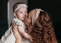 Beautiful young mother kisses her baby daughter and holds her in her arms Royalty Free Stock Photo