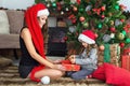 Beautiful young mother makes to the little daughter a Christmas gift.