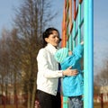 Beautiful young mother playing with her baby on the playground