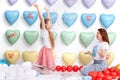 Beautiful Young Mother And A Pretty Little Daughter, The Family On A Colorful Hearts Background, Are Smiles, Funny