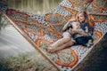 Beautiful young mother resting on hammock near a lake with her little child, family vacation concept, mother and son on a camping Royalty Free Stock Photo