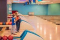 beautiful young mother and son playing bowling with medical masks during COVID-19 coronavirus in bowling club Royalty Free Stock Photo