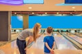 beautiful young mother and son playing bowling with medical masks during COVID-19 coronavirus in bowling club Royalty Free Stock Photo