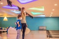 beautiful young mother and son playing bowling with medical masks during COVID-19 coronavirus in bowling club Royalty Free Stock Photo