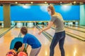 beautiful young mother and son playing bowling with medical masks during COVID-19 coronavirus in bowling club Royalty Free Stock Photo