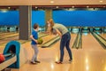 beautiful young mother and son playing bowling with medical masks during COVID-19 coronavirus in bowling club Royalty Free Stock Photo