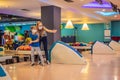 beautiful young mother and son playing bowling with medical masks during COVID-19 coronavirus in bowling club Royalty Free Stock Photo