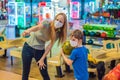 beautiful young mother and son playing bowling with medical masks during COVID-19 coronavirus in bowling club Royalty Free Stock Photo