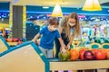 beautiful young mother and son playing bowling with medical masks during COVID-19 coronavirus in bowling club Royalty Free Stock Photo