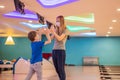 beautiful young mother and son playing bowling with medical masks during COVID-19 coronavirus in bowling club Royalty Free Stock Photo