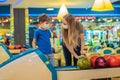 beautiful young mother and son playing bowling with medical masks during COVID-19 coronavirus in bowling club Royalty Free Stock Photo