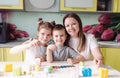 A beautiful young mother with two children decorated traditional Easter eggs with bright paint, the concept of a happy family. Royalty Free Stock Photo