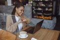 Beautiful African woman in love, holding heart shaped fingers, smiling while talking with her boyfriend via video call. Royalty Free Stock Photo