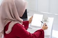 Beautiful young muslim woman using tablet mockup in modern white office. Royalty Free Stock Photo