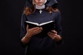Pretty young nun in religion concept against dark background. Royalty Free Stock Photo