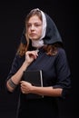 Pretty young nun in religion concept against dark background. Royalty Free Stock Photo