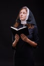 Pretty religious nun against dark background. Religion concept. Royalty Free Stock Photo