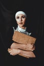 Beautiful young nun in religion black suit holds Bible. Religion concept Royalty Free Stock Photo