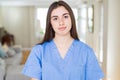 Beautiful young nurse woman at the clinic with serious expression on face Royalty Free Stock Photo