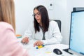 Beautiful young nutritionist woman explaining to her patient the diet he should follow to lose weight in the consultation