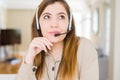 Beautiful young operator woman wearing headset at the office with hand on chin thinking about question, pensive expression Royalty Free Stock Photo