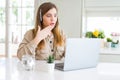 Beautiful young operator woman working with laptop and wearing headseat cover mouth with hand shocked with shame for mistake, Royalty Free Stock Photo