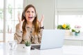 Beautiful young operator woman working with laptop and wearing headseat crazy and mad shouting and yelling with aggressive Royalty Free Stock Photo