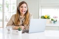 Beautiful young operator woman working with laptop and wearing headseat with a happy and cool smile on face Royalty Free Stock Photo