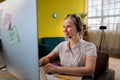 Beautiful young operator woman working with laptop and wearing headseat looking away to side with smile on face, natural Royalty Free Stock Photo