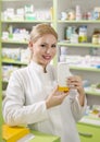 Beautiful young pharmacist girl holding medicine box