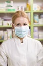 Beautiful young pharmacist with surgical mask