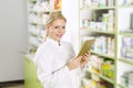 Beautiful young pharmacist with tablet