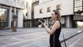Beautiful young photographer woman takes photos outdoors of a modern business district. Action. Camera moving around a Royalty Free Stock Photo