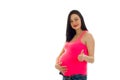 Beautiful young pregnant brunette woman touching her belly and showing thumbs up isolated on white background Royalty Free Stock Photo