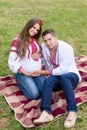 Beautiful young pregnant couple dressed in national ukrainian style having picnic in autumn park. Maternity and family happyness