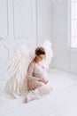 Beautiful young pregnant girl with big angel wings Royalty Free Stock Photo