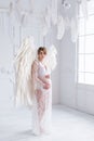 Beautiful young pregnant girl with big angel wings Royalty Free Stock Photo