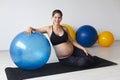 Beautiful, young, fit, athletic and pregnant woman with black hair doing fitness exercises in a modern apartment Royalty Free Stock Photo