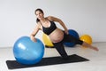 Beautiful, young, fit, athletic and pregnant woman with black hair doing fitness exercises in a modern apartment Royalty Free Stock Photo