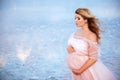 Beautiful young pregnant woman enjoying the sun on pink lake Royalty Free Stock Photo