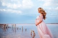 Beautiful young pregnant woman enjoying the sun on pink lake Royalty Free Stock Photo