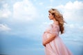 Beautiful young pregnant woman enjoying the sun on pink lake Royalty Free Stock Photo