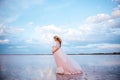 Beautiful young pregnant woman enjoying the sun on pink lake Royalty Free Stock Photo