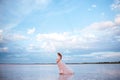 Beautiful young pregnant woman enjoying the sun on pink lake Royalty Free Stock Photo