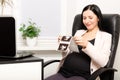 Beautiful young pregnant woman, looking at ultrasound pictures of her baby