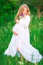 Beautiful young pregnant woman relaxing in nature on a beautiful sunny day Royalty Free Stock Photo