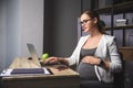 Young pregnant business woman using a laptop in the office Royalty Free Stock Photo