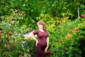 Beautiful young pregnant woman is standing in the summer near a garden Royalty Free Stock Photo
