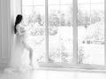 beautiful young pregnant woman in white dress stands near window Royalty Free Stock Photo