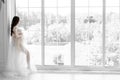 beautiful young pregnant woman in white dress stands near the window black white photo Royalty Free Stock Photo